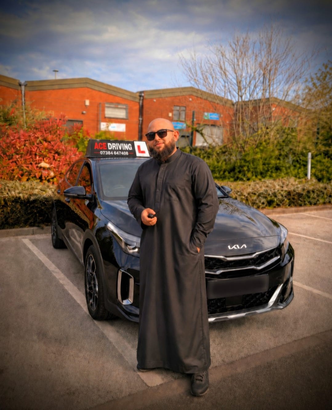 Ahad, founder of Ace Driving Institute, beside his branded Kia teaching car